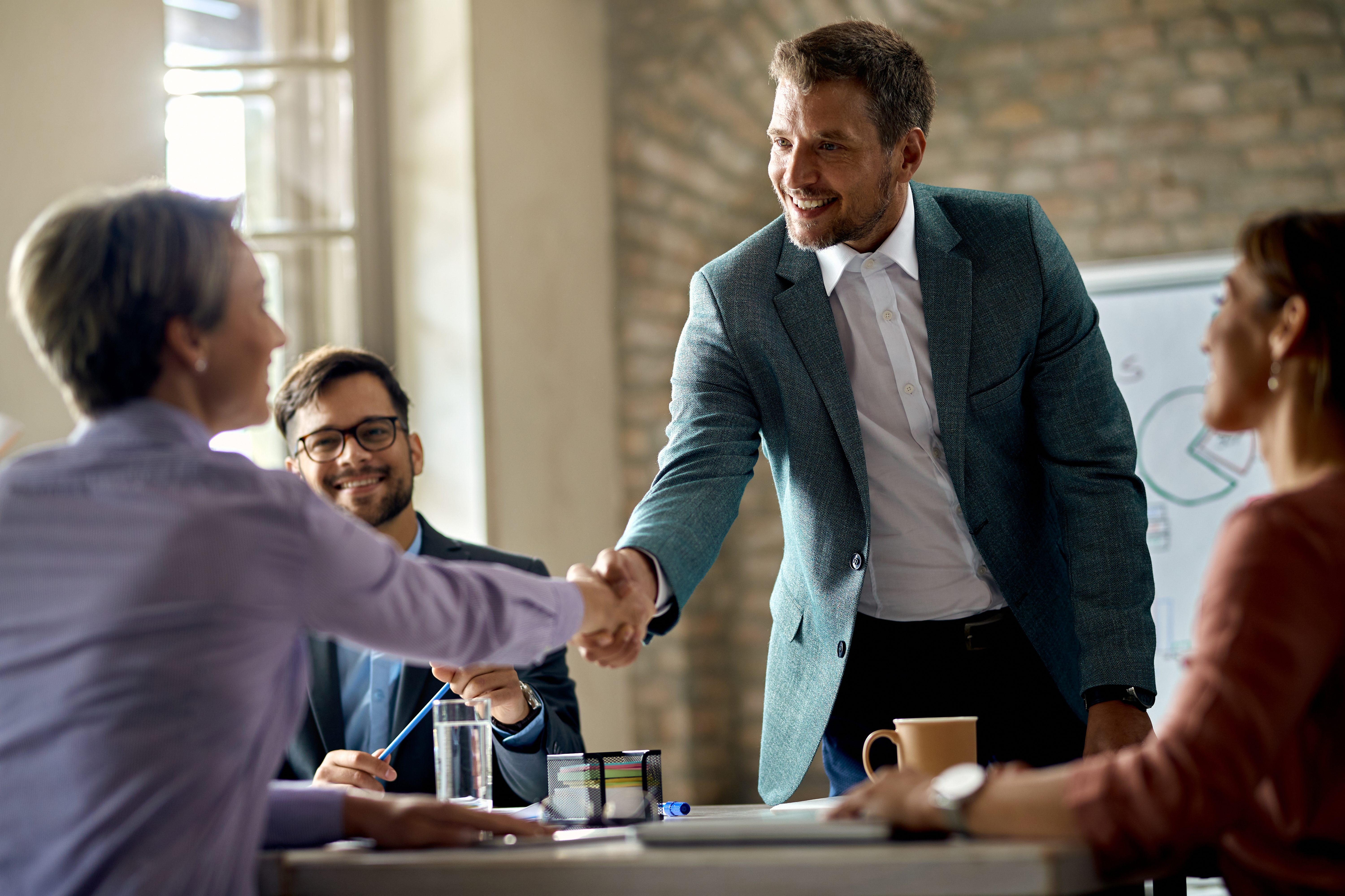 Happy businessman greeting a female colleague on a meeting in th Happy businessman greeting a female colleague on a meeting in th